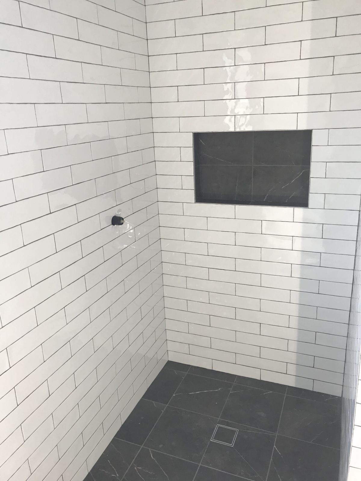 Subway tiled shower with a recessed niche